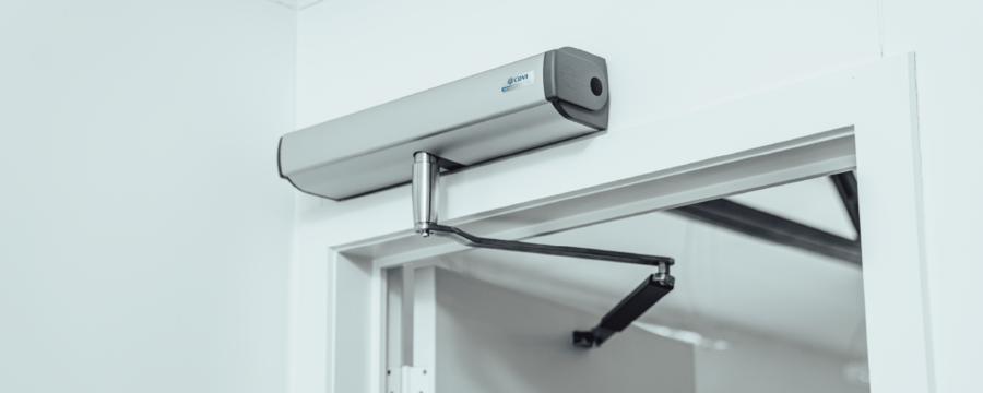 Automatic door operator for swing doors mounted above door frame with door held open