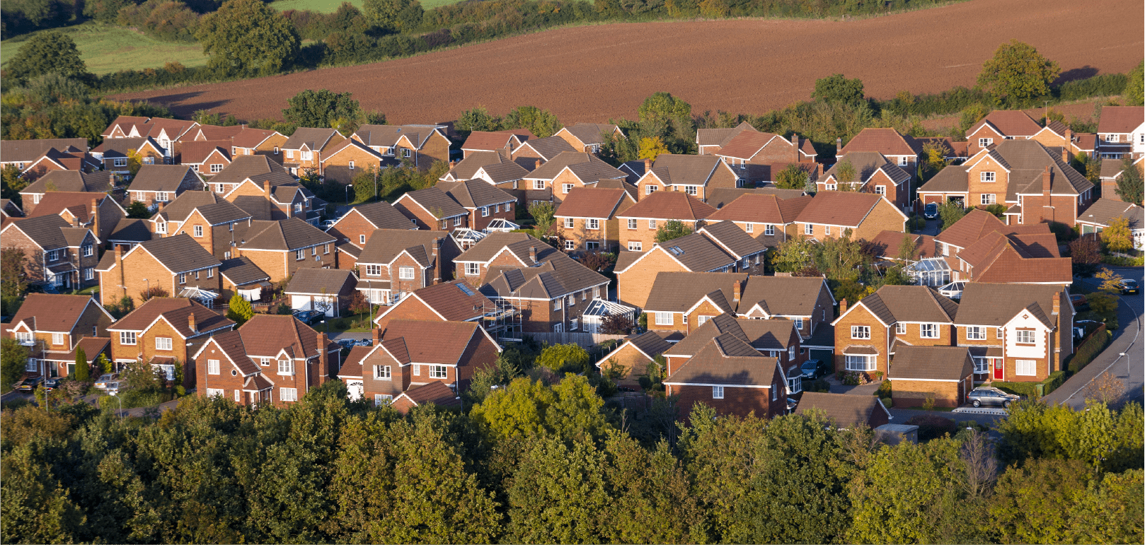 Wide shot from the air of a British town or village with a group of detached modern houses