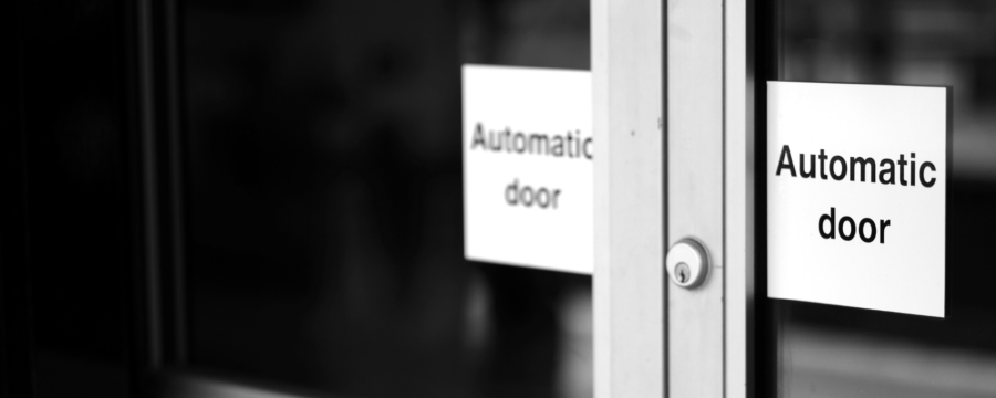 Automatic door sensors | black and white photo of an automatic door sign