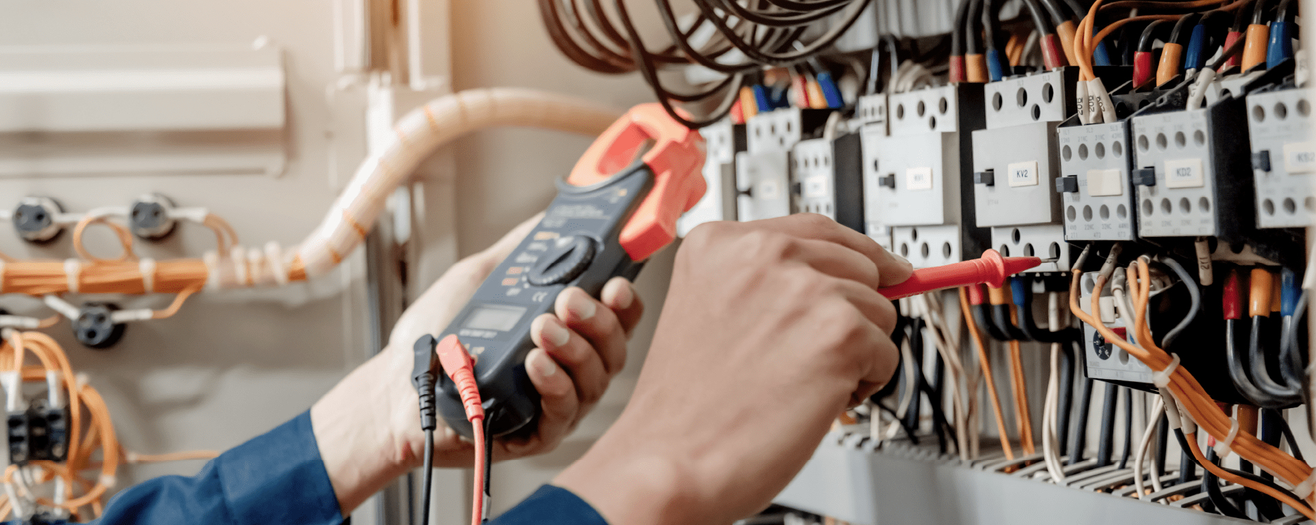 Electrician testing voltage and current on a DIN rail